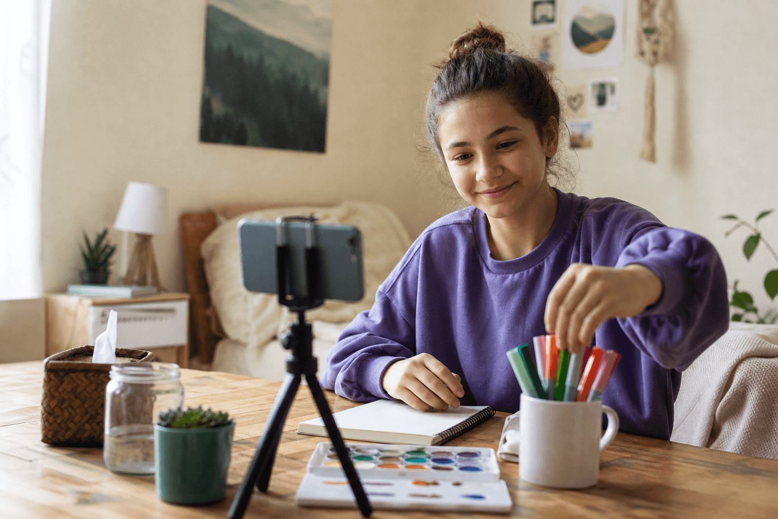 Teen setting up watercolor and markers at home for a virtual art therapy session